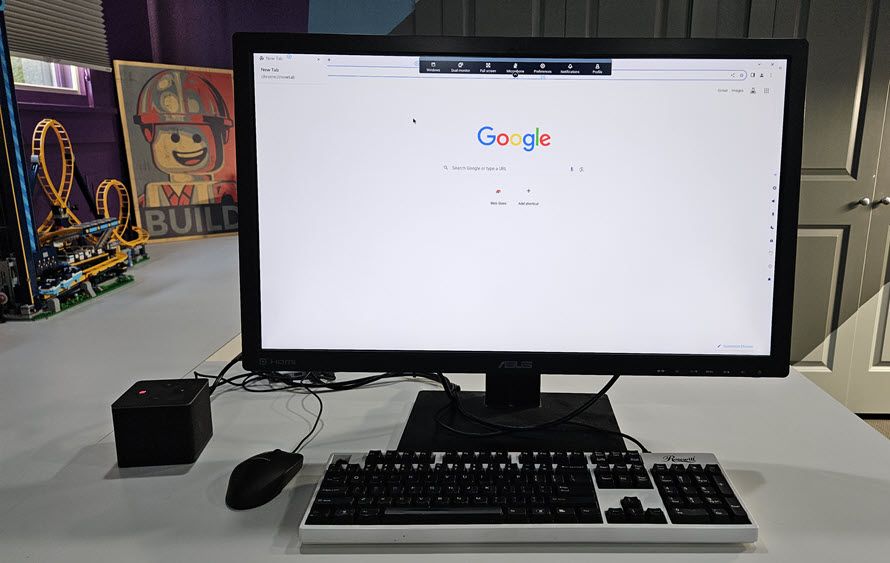 AWS&#039; Amazon WorkSpaces Thin Client, a small box computer plugged into an ASUS monitor which is displaying Google search. Both are sat on a white desk in a study, with a keyboard set in front.