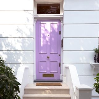 front door with white walls and stairs