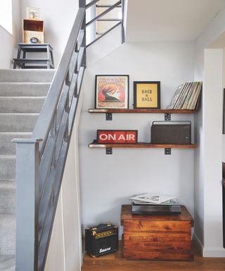 Small entryway nook with art on shelf and small wooden cabinet