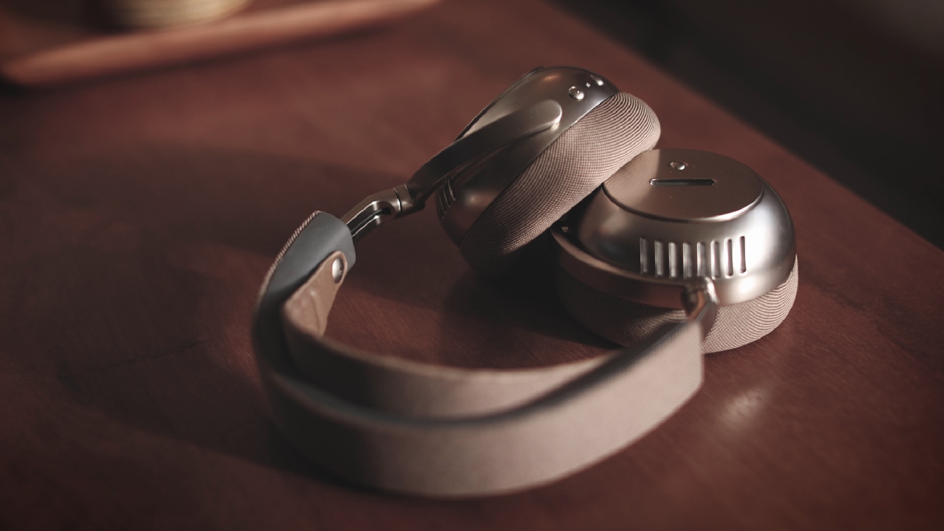 A pair of &amp;Eacute;coute TH1 over-ear headphones lying on a wooden surface.