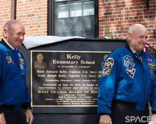 Mark and Scott Kelly peeked under the cloth covering the plaque in their honor at Kelly Elementary School right when they came out in front of the school, but they had to wait to fully reveal it until near the end of the ceremony.