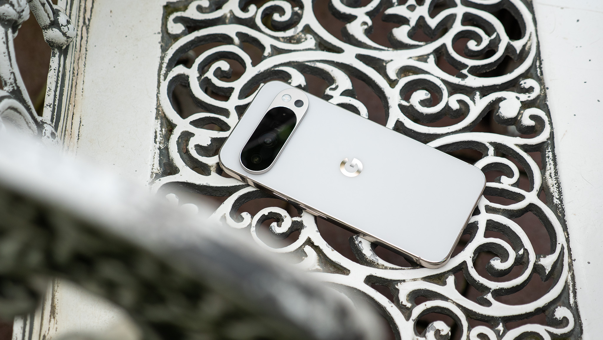 A white Google Pixel 10 Pro XL on a latticework white metal chair