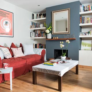 living room with red sofa and wooden flooring