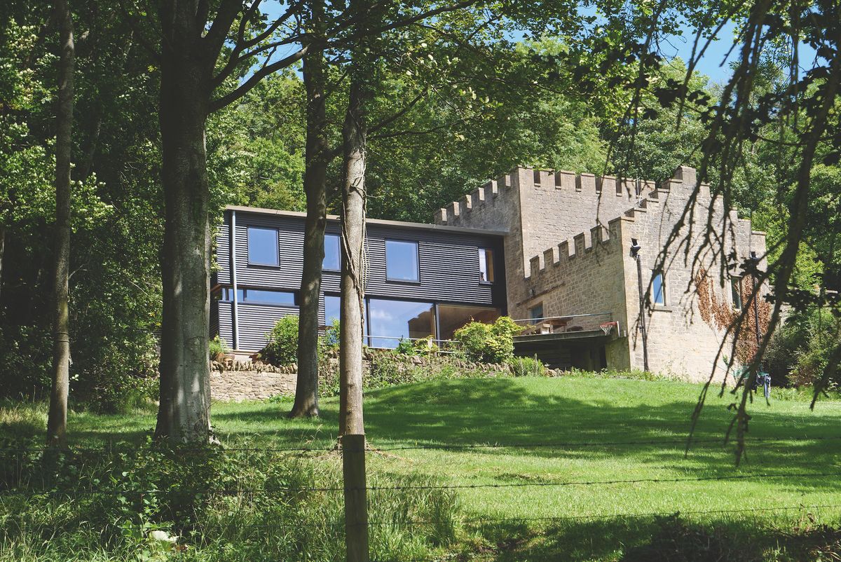 black corrugated metal extension to stone traditional building
