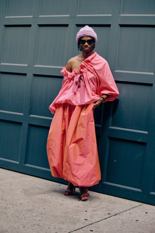 Jalil Johnson at New York Fashion Week in a pink Christopher John Rogers blouse and pink balloon pants and red heels