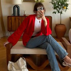 @juliesfi wearing a red cardigan, white crewneck, blue jeans, Chanel bag, and cap-toe slingback heels