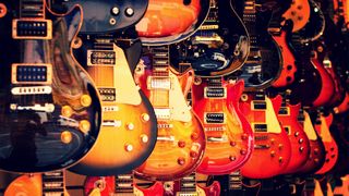 A wall of electric guitars hanging for sale in a store
