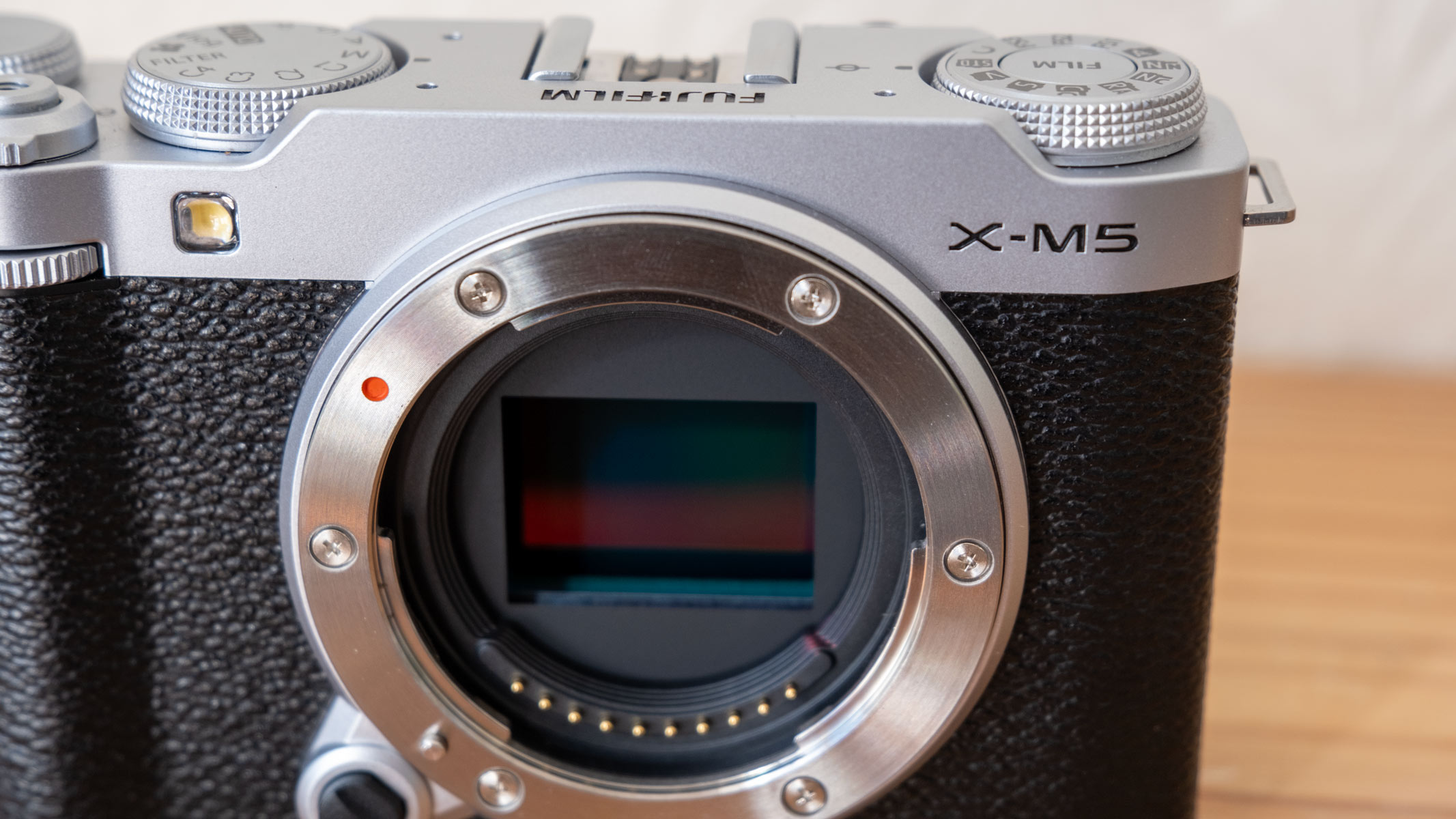 A close-up of the Fujifilm X-M5, showing a red and green sensor.