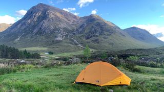 One-person tent pitched near Scottish mountains