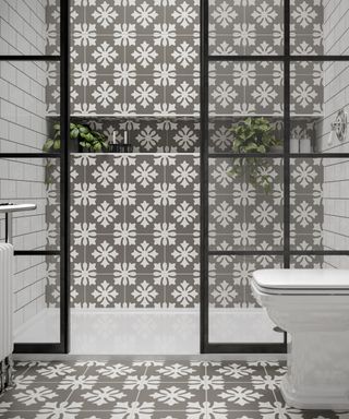 A shower enclosure with gray patterned tiles.