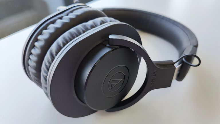 Audio-Technica ATH-M20xBT review: woman writing on a notepd with headphones on