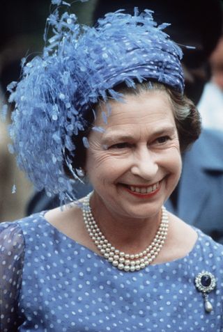 The Queen In The Solomon Isles During Her Official Tour Of The South Pacific Islands Wearing A Hat With Feathers (designed By Milliner Frederick Fox), Three-strand Pearl Necklace And The Empress Marie Feodorovna Of Russia's Sapphire, Diamond And Pearl Brooch.