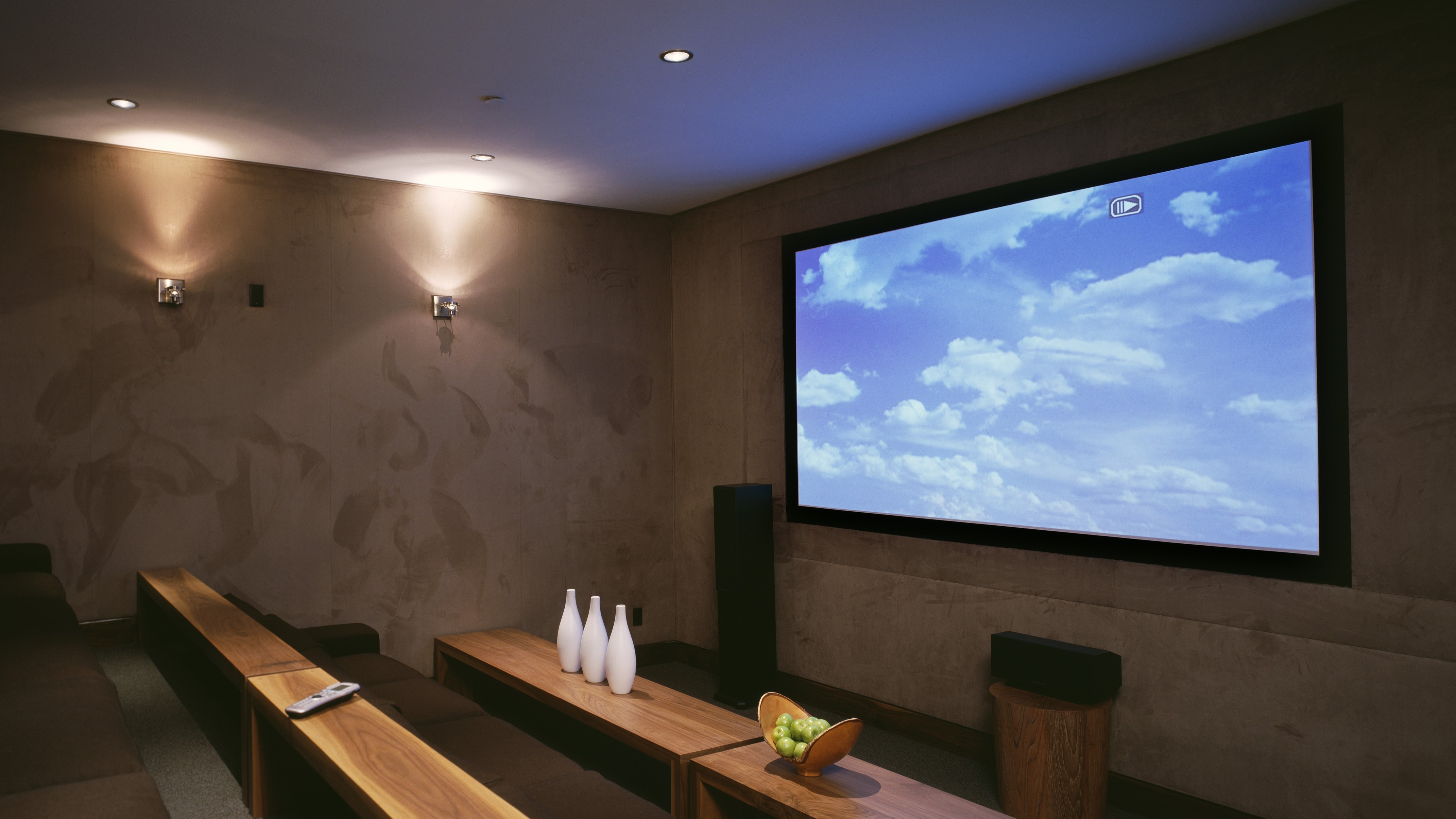 Home cinema with ceiling spotlights and wall sconces