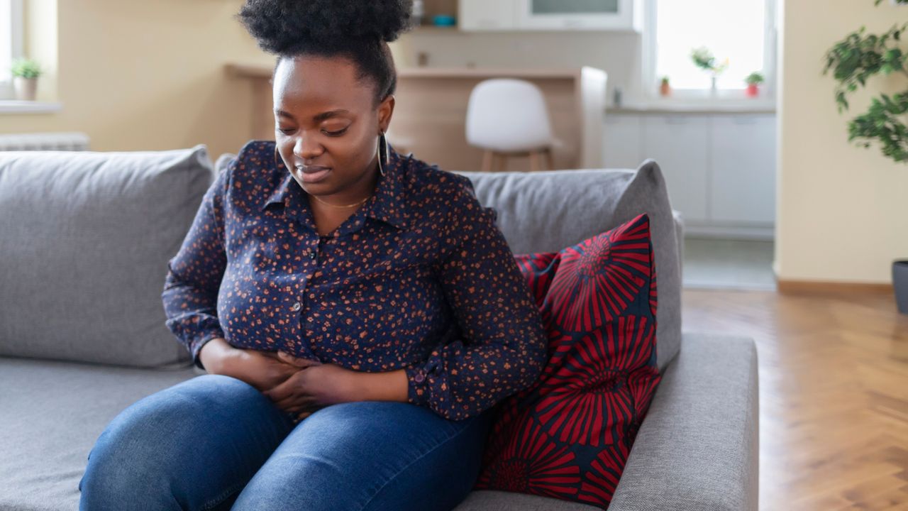 Woman clutching her stomach as a result of painful bloating