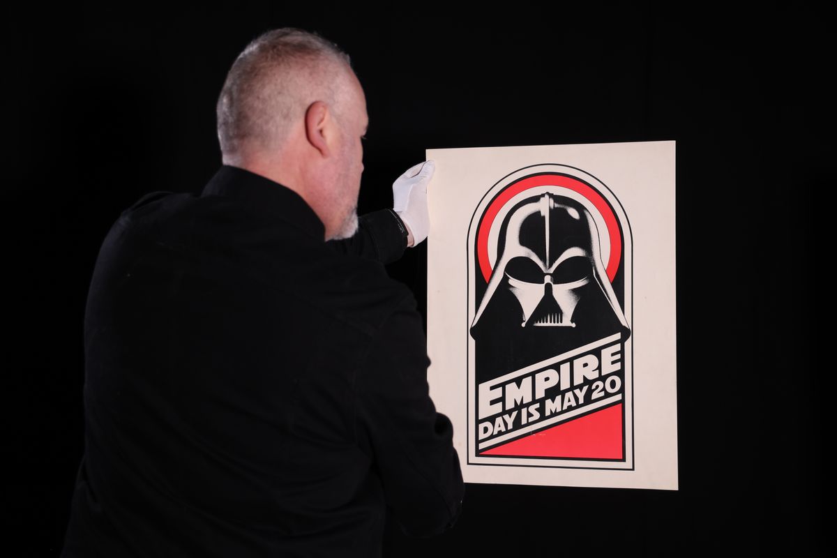 The Empire Strikes Back movie poster featuring Darth Vader&#039;s mask and the phrase &quot;Empire Day is May 20&quot;