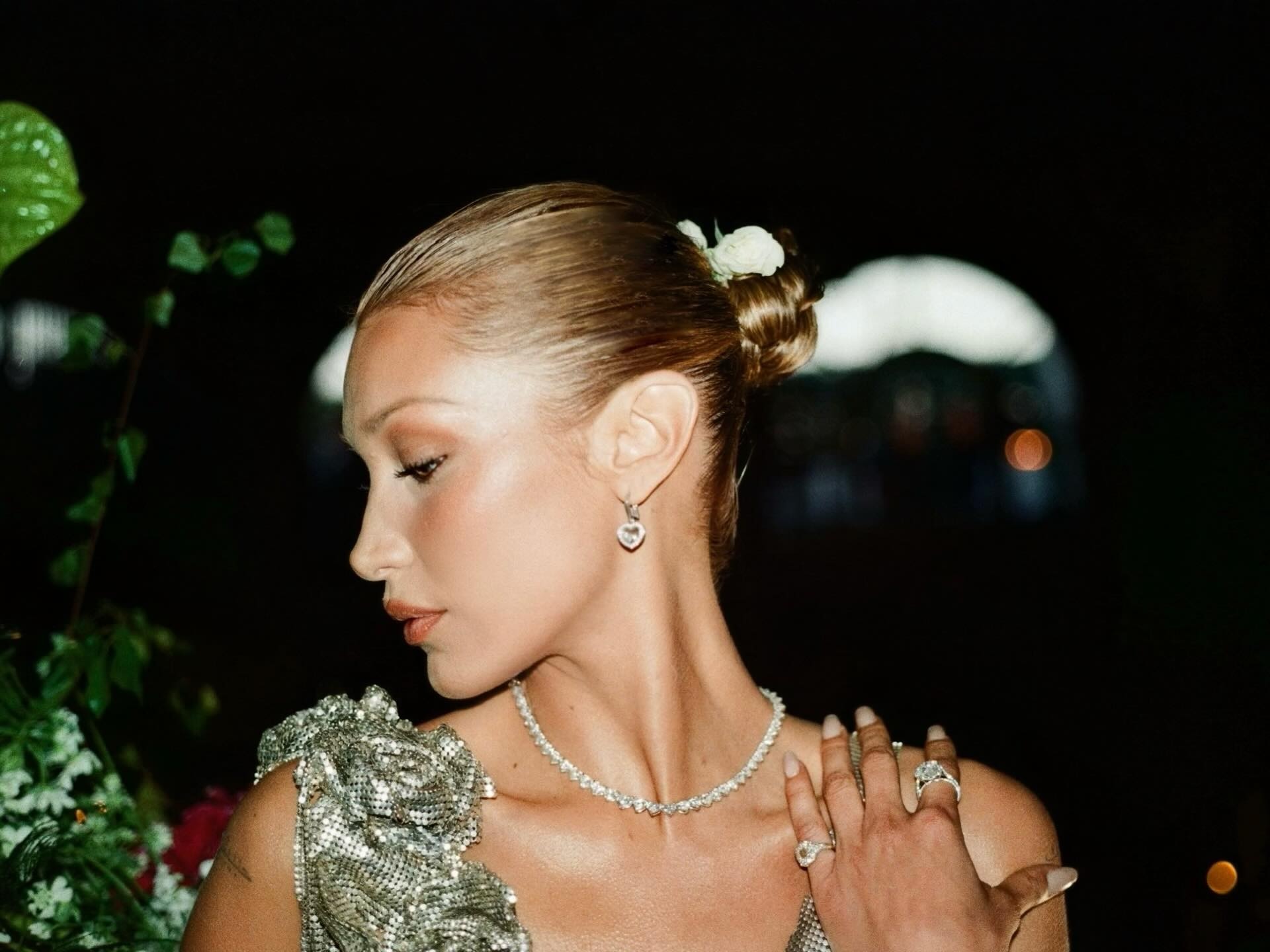 bella hadid with jewels and a silver sparkly dress featuring a slick-back bun