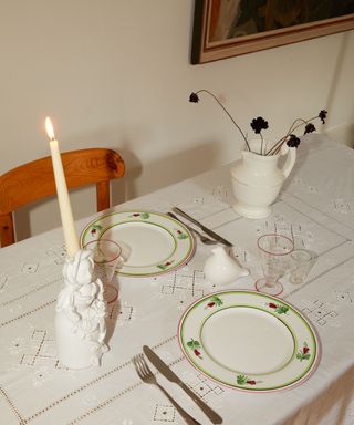 white lace tablecloth styled with decorative plates and vintage style candle holders and vases