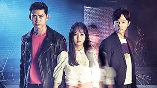 a woman (center) stands with two men on each side, in front of a smoky room with a brick wall, in the korean drama 'bring it on, ghost'