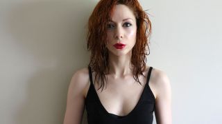 The Anchoress posed image with wet hair against a grey wall