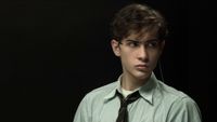 Jacob Tremblay wearing a dress shirt and tie strapped in for the Harvard Interrogation Experiments in Unabomber.