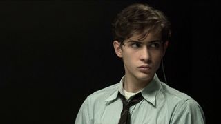 Jacob Tremblay wearing a dress shirt and tie strapped in for the Harvard Interrogation Experiments in Unabomber.