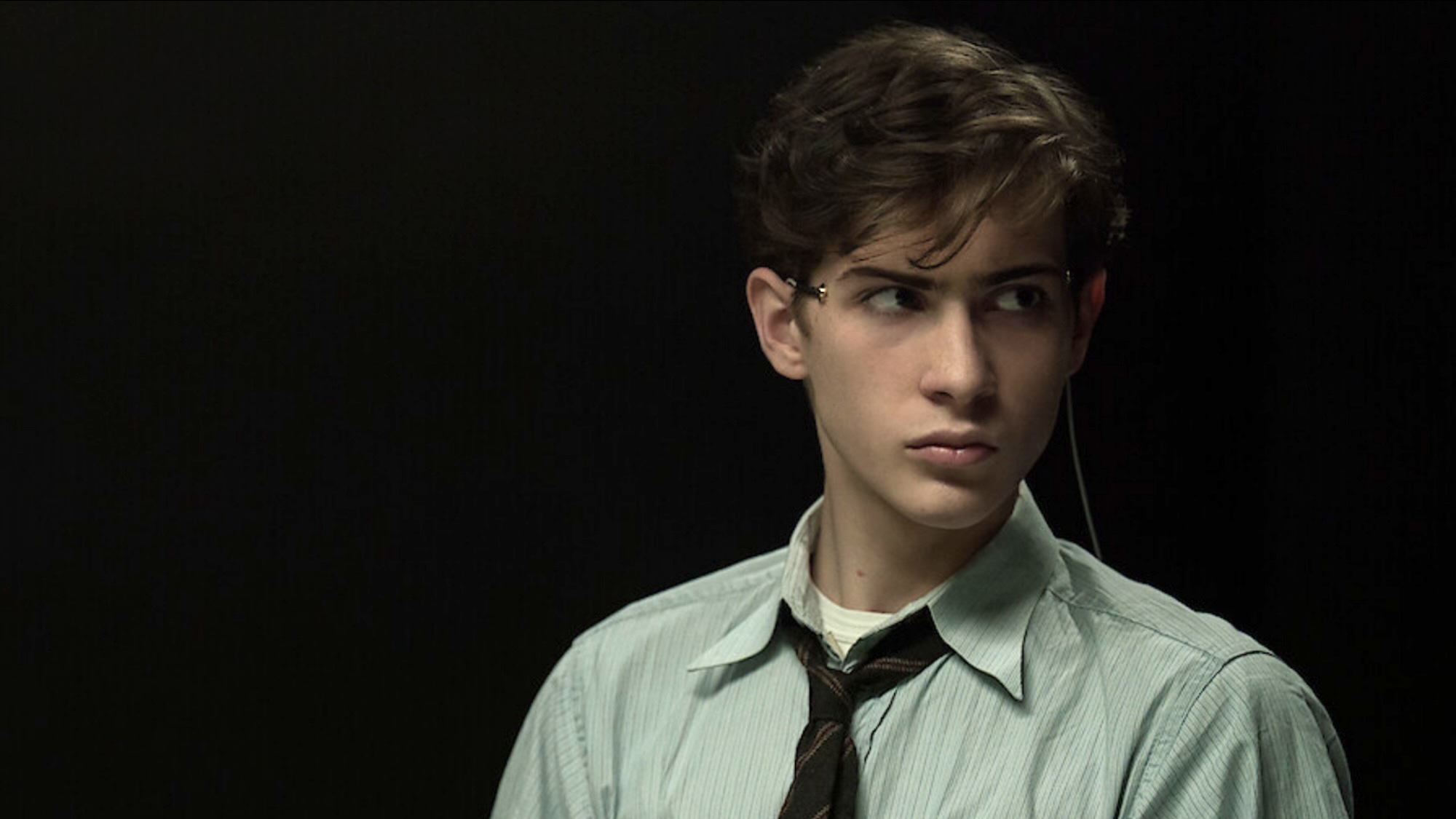 Jacob Tremblay wearing a dress shirt and tie strapped in for the Harvard Interrogation Experiments in Unabomber.