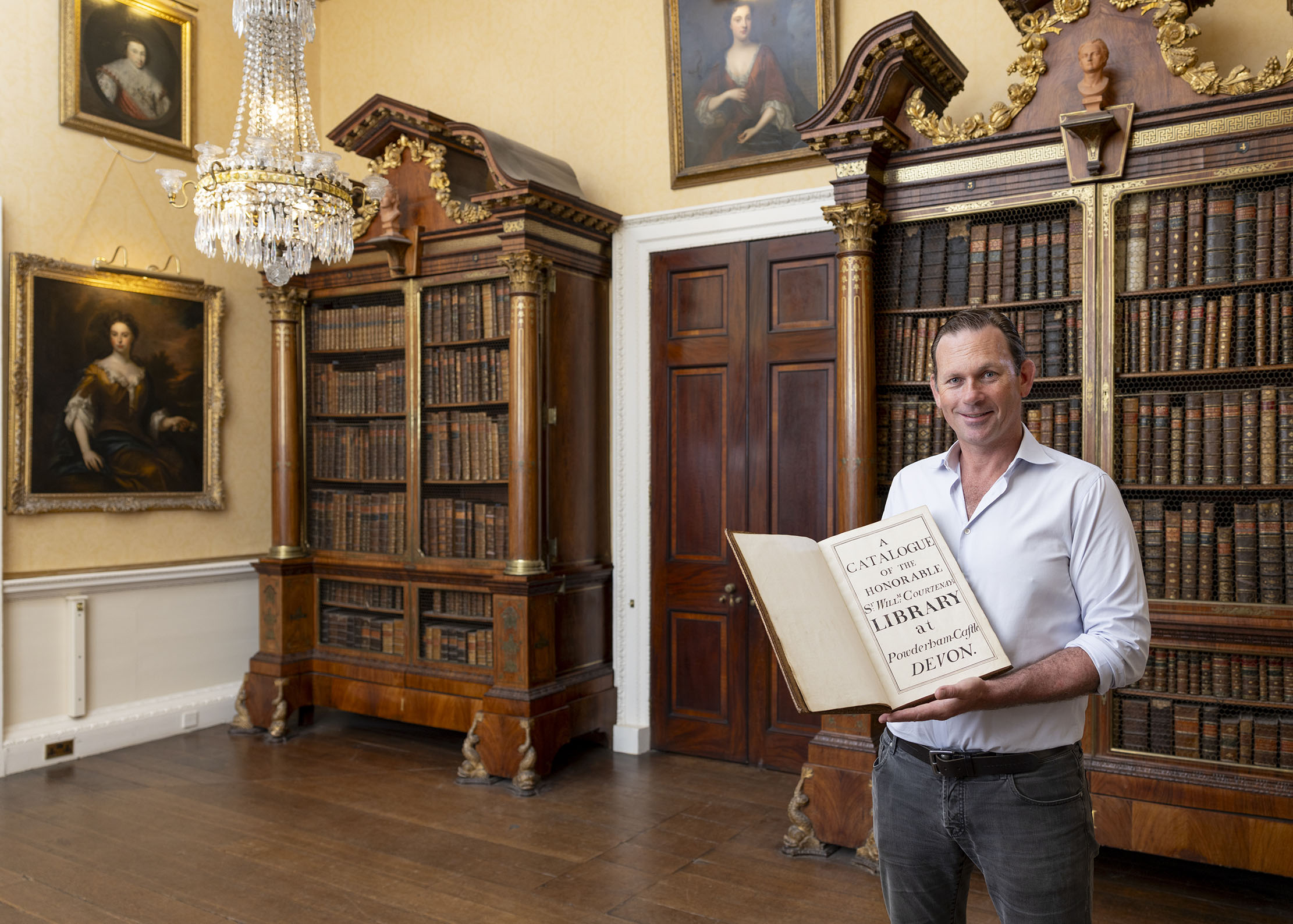 Charlie Courtenay, 19th Earl of Devon with his ancestor's book at Powderham Castle.