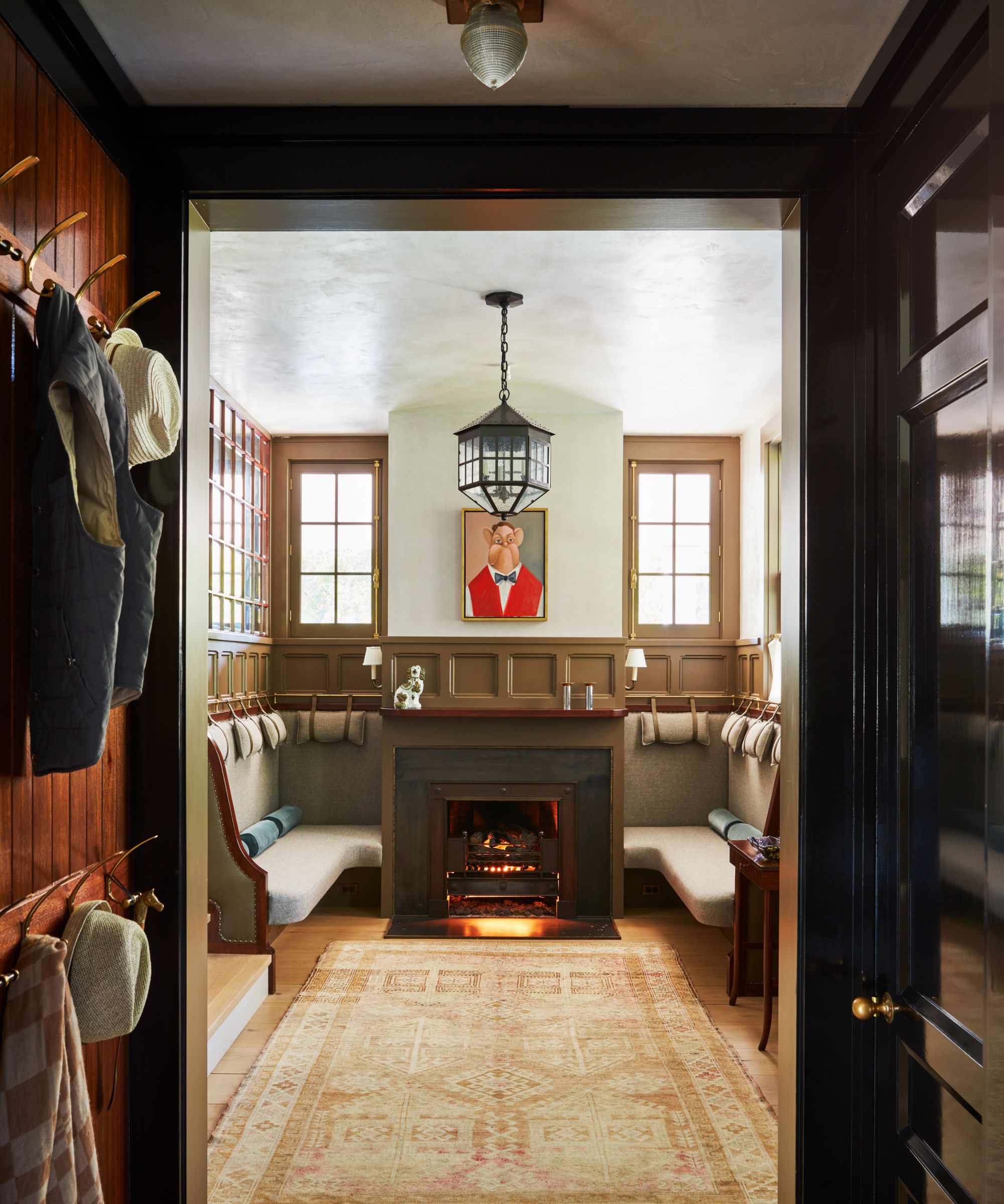 Snug with a fire, banquettes and a large rug with wood-panelled walls