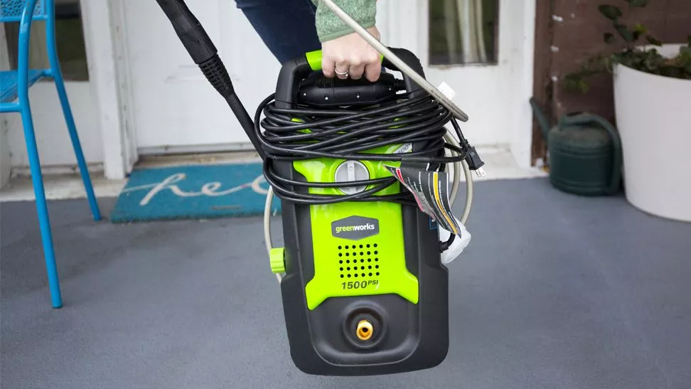 Woman carrying the Greenworks GPW1501 by the handle