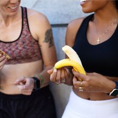 Best foods for hormones: A woman eating a banana after a workout