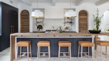 kitchen island in marble with blue cabinet base and additional wooden worktop 