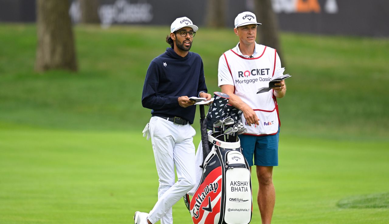 Akshay Bhatia speaks to his caddie on the fairway