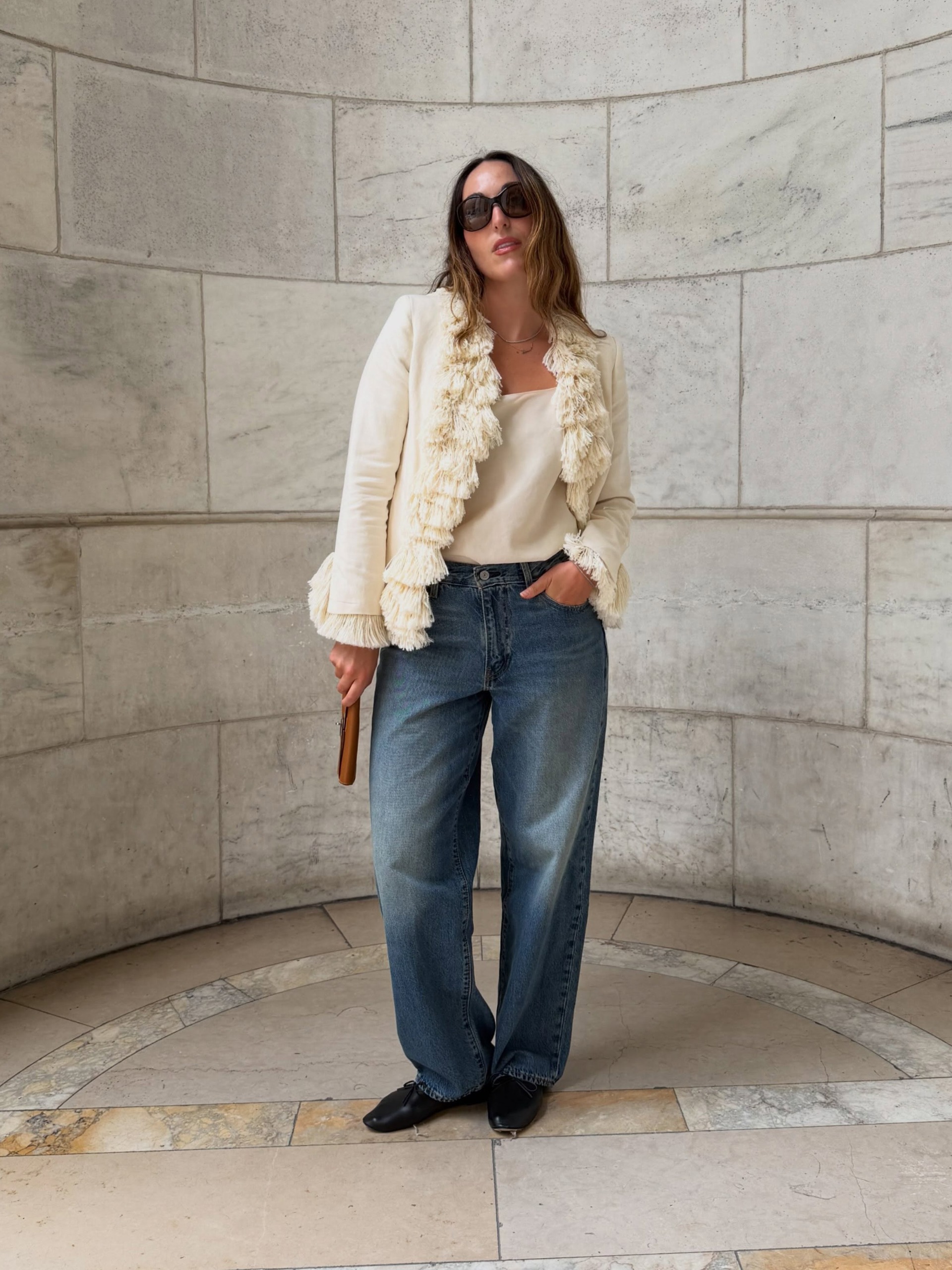 Stylish woman wearing a fringed jacket with jeans and high-vamp ballet flats