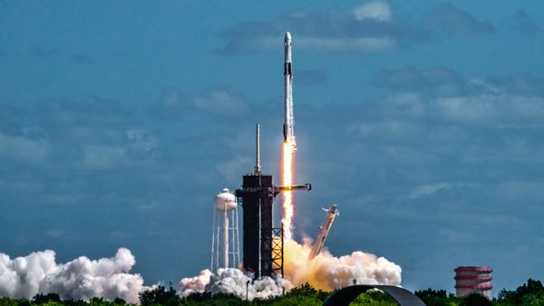 a rocket lifting off into the sky with a plume of smoke and fire below