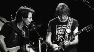 Nils Lofgren performing onstage with Neil Young in 1982