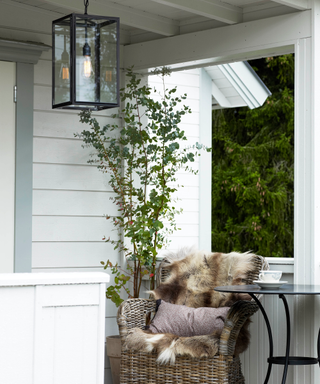 Front porch ideas by Davey Lighting with porch light, chair, table and faux fur