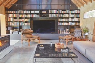 modern living room with stove on left and tv on wall surrounded by books