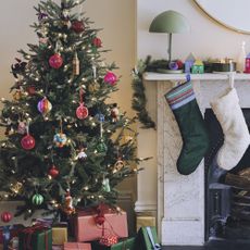 Habitat Christmas tree in living room with stocking hanging on mantelpiece.