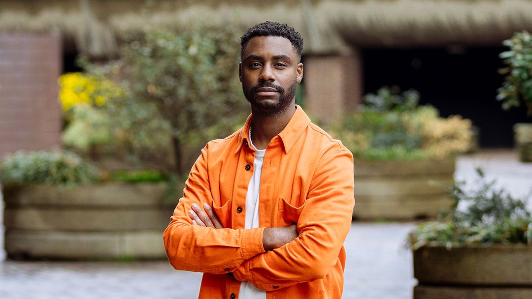 Kieron Lewis headshot - man in an orange shirt