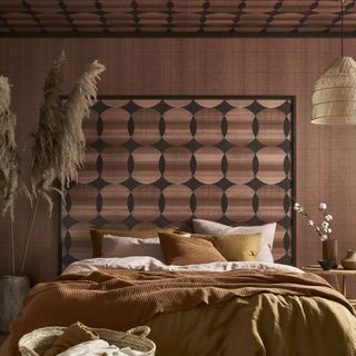 Pink, brown and orange bedroom with wallpaper headboard