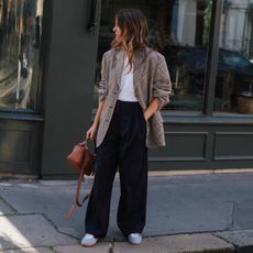 @kimturkington_ wears a pair of black wide-leg trousers from COS with a checked blazer
