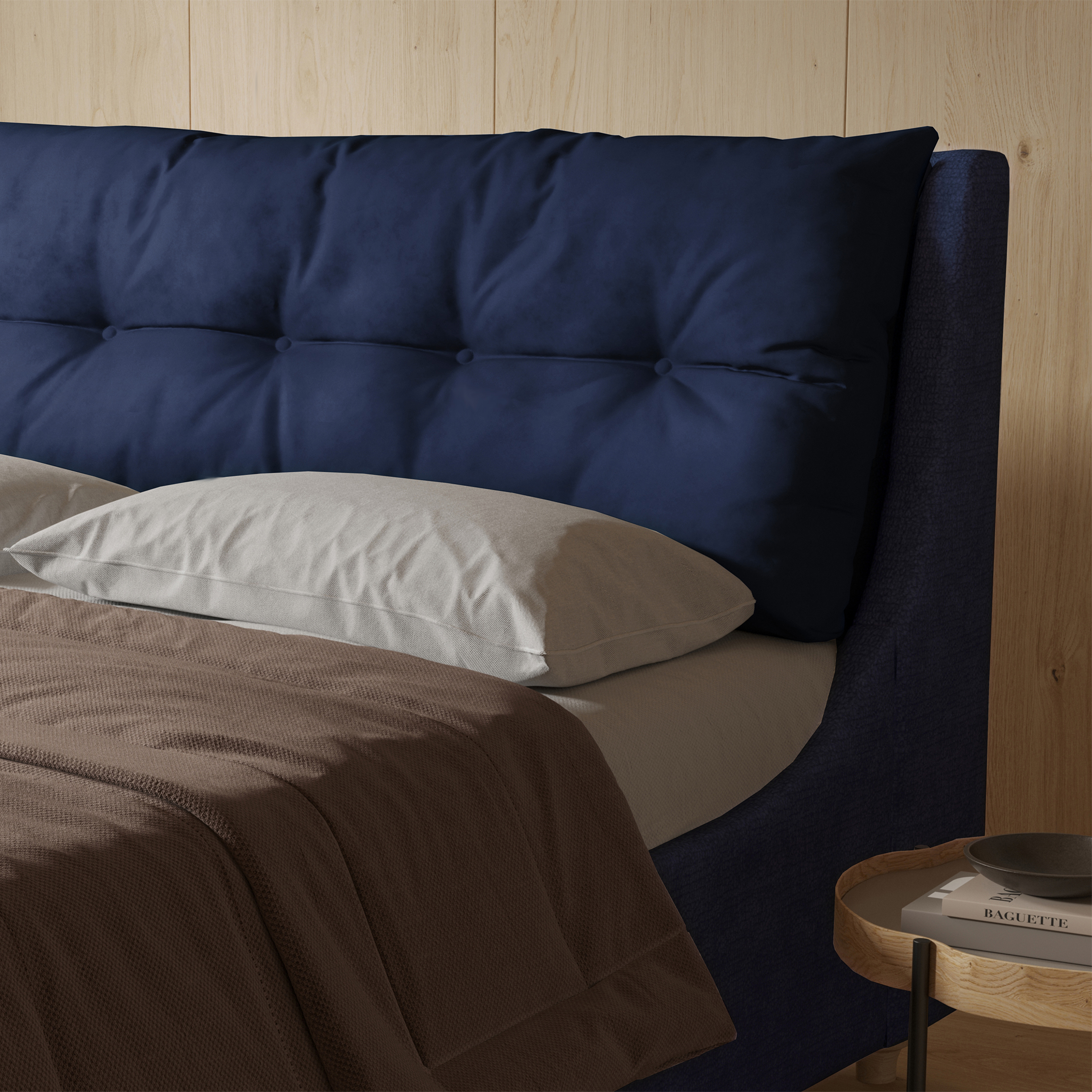 Blue cushioned headboard in front of a pale wood wall