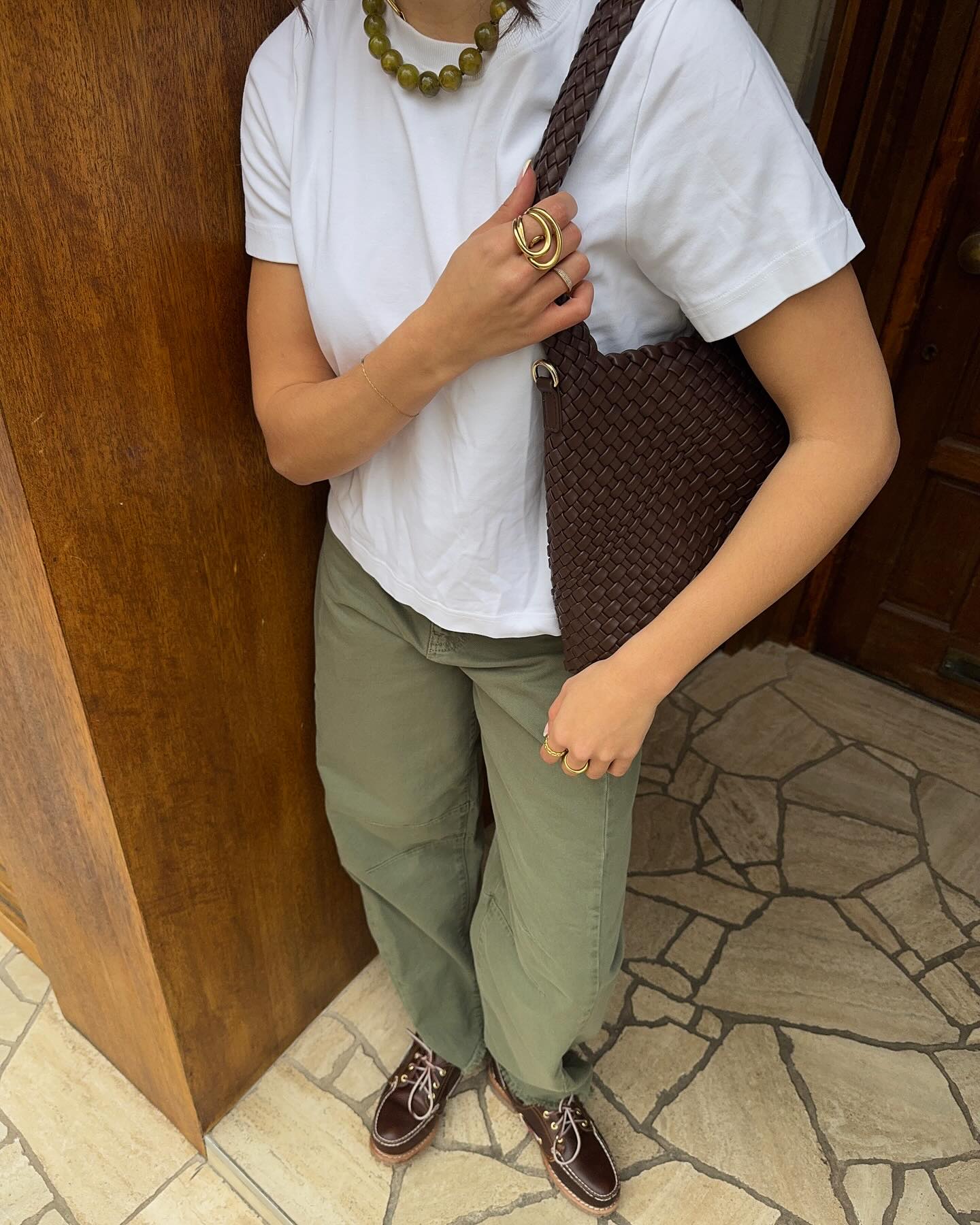 Tia Dewitt wears green jeans with a white t-shirt and brown boat shoes