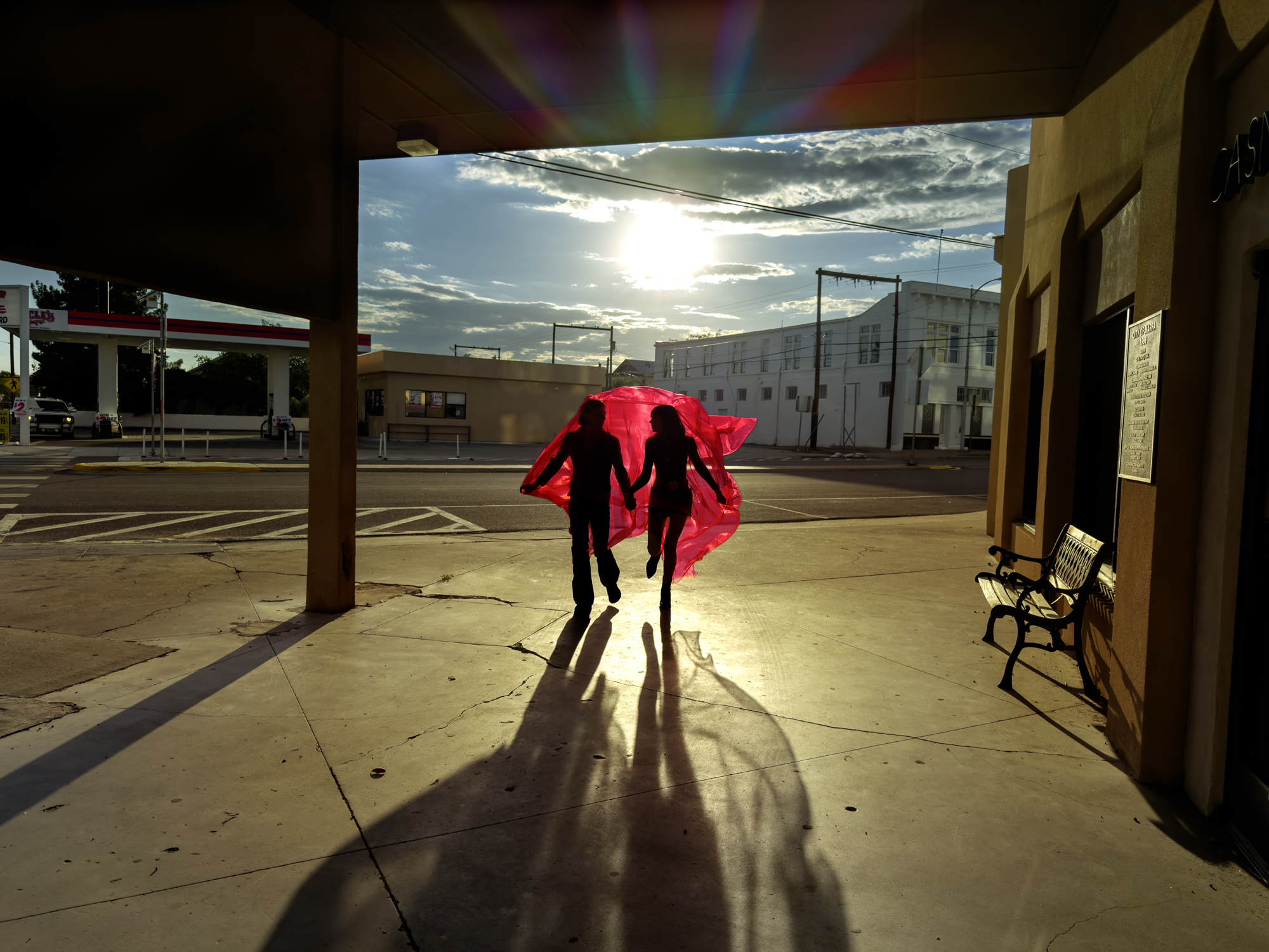 man and woman with red sheet in the desert