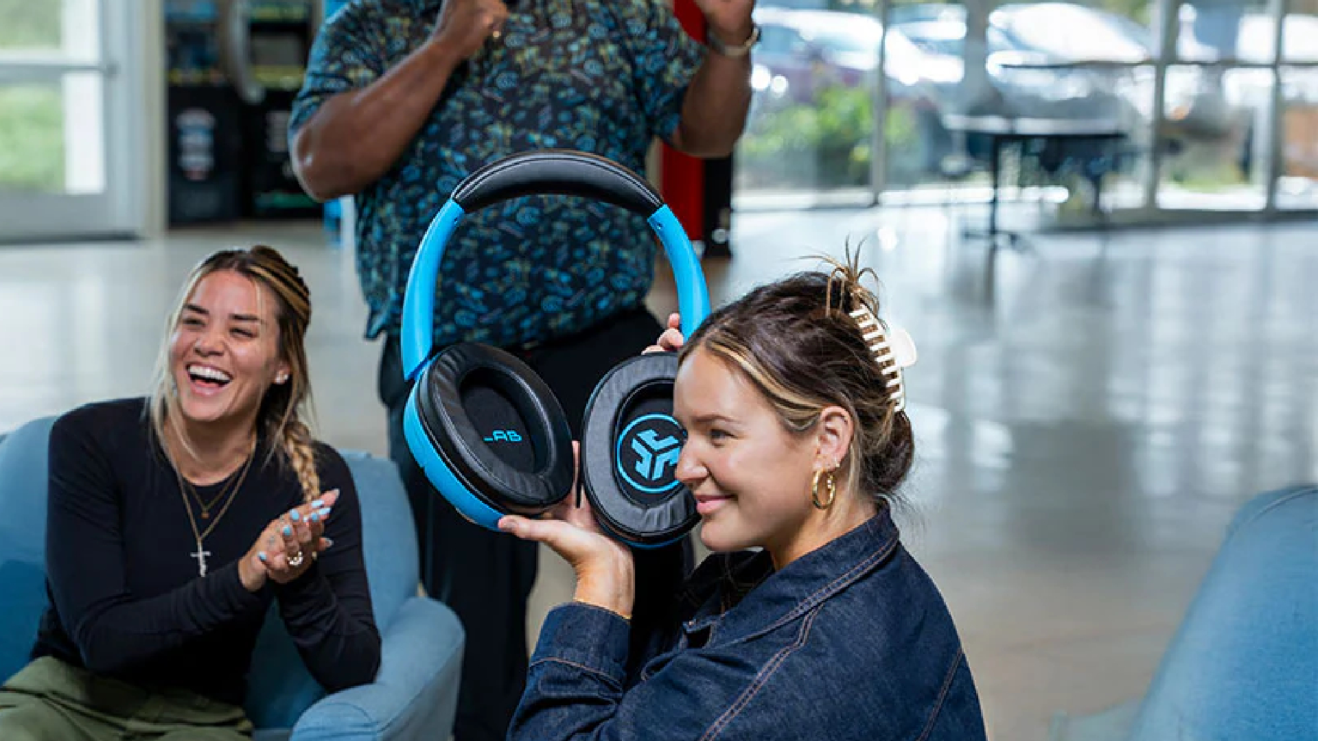 Models demonstrating JLab Audio's oversized Blue XL headphones