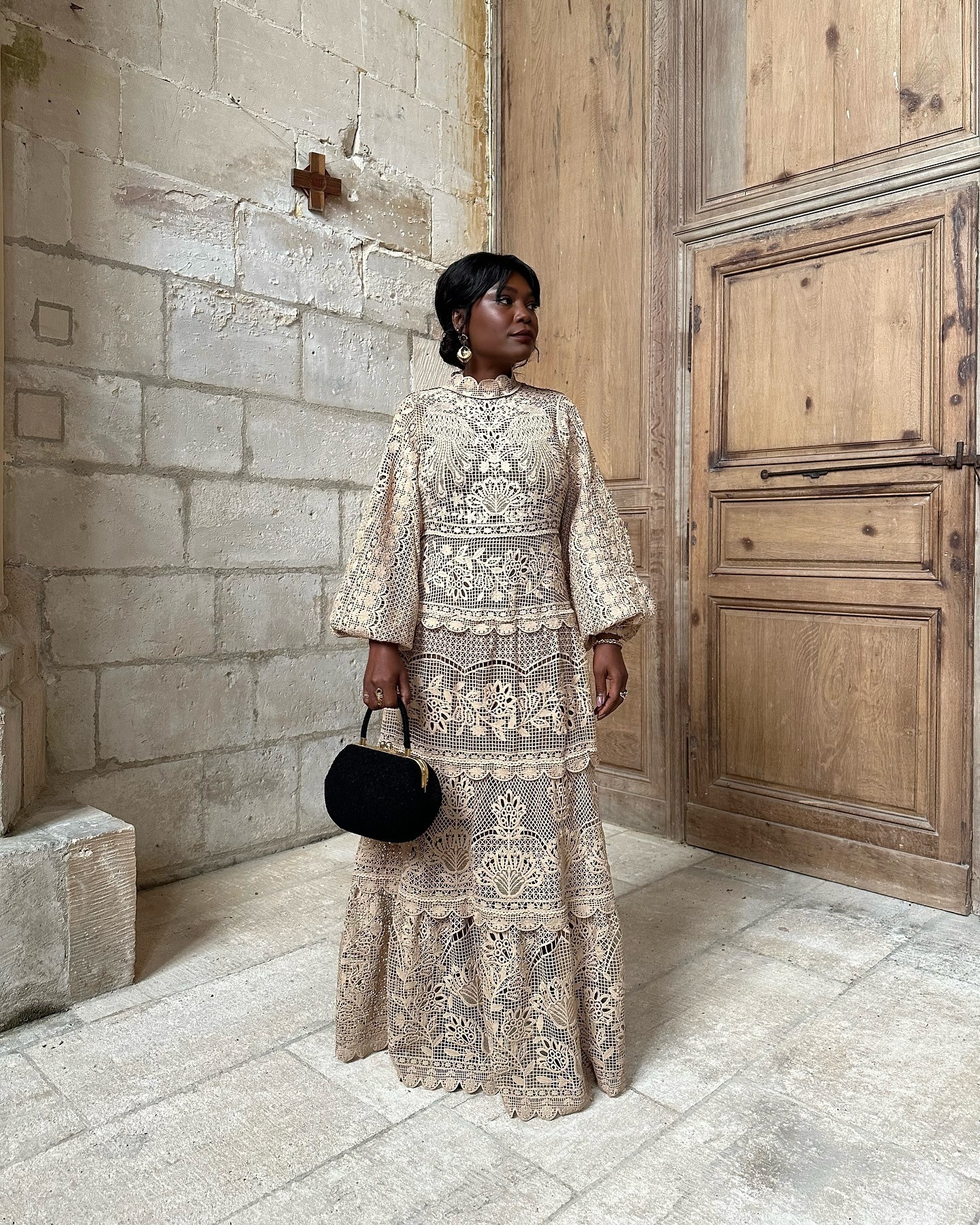 A woman in Paris wearing a dress with her bob hairstyle styled in a bun with curtain bangs
