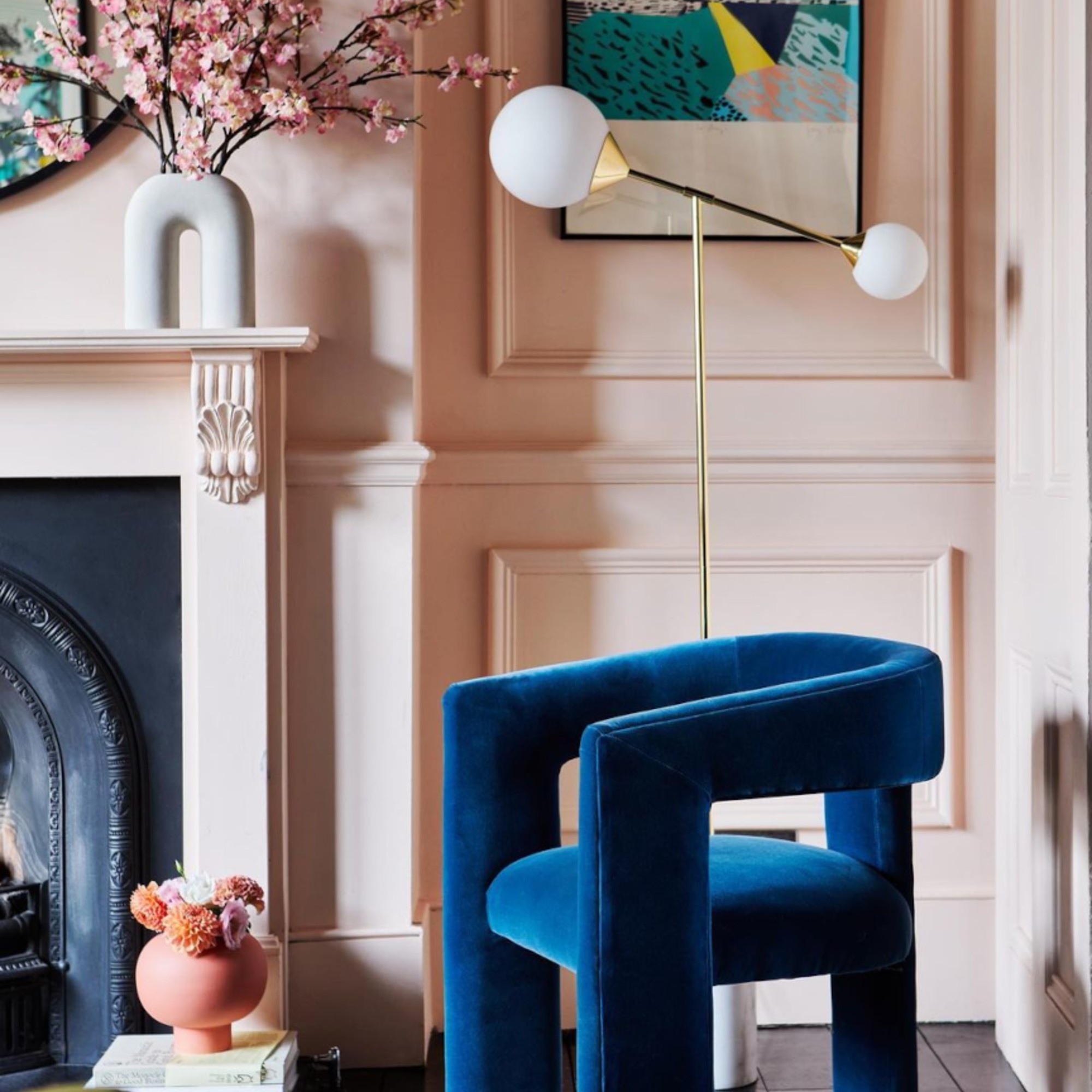 A pink living room painted in Valspar's Bare Necessity with a blue velvet accent chair