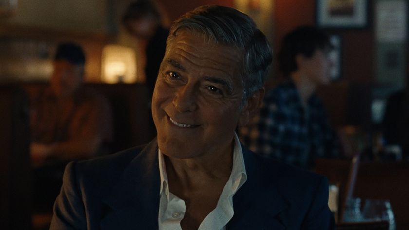 George Clooney smiling at dinner with 