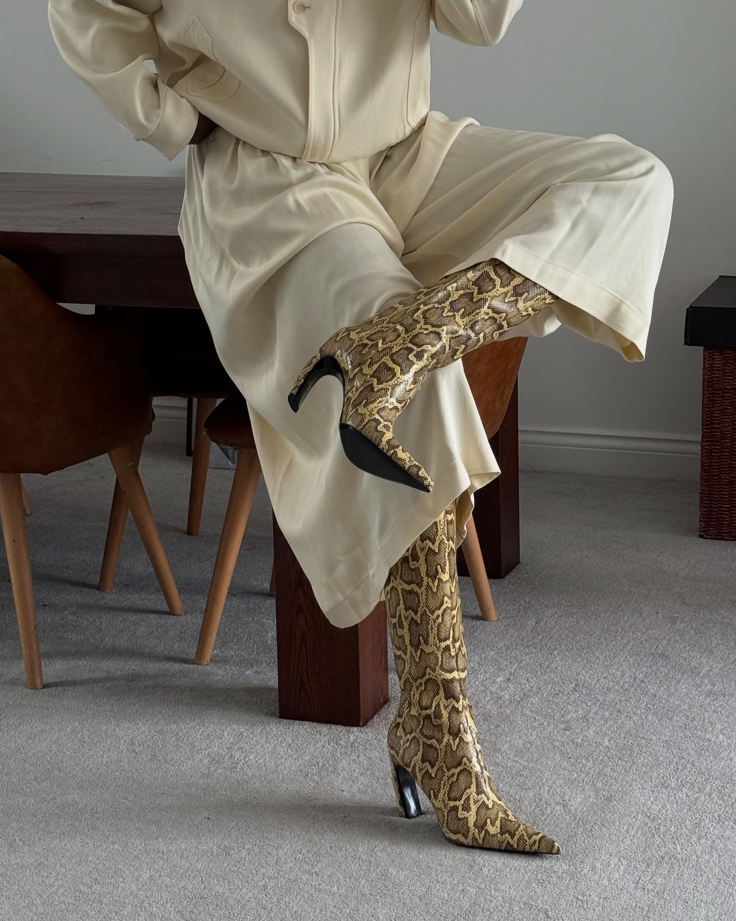 @nlmarilyn wears a pair of snake-print knee boots with cream cropped trousers