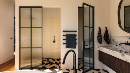 black and white bathroom with Crittall-style doors and marble countertop
